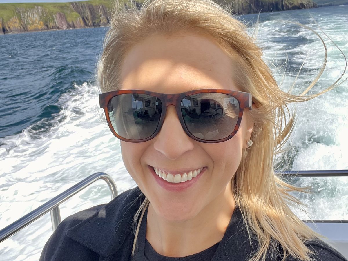 Open water and a boat wake, with the coastline behind